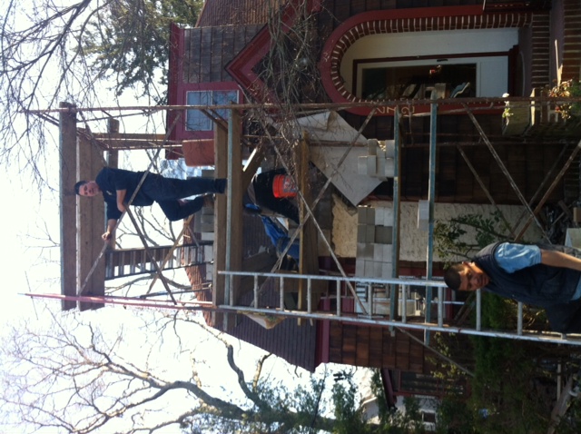 Men climbing scaffolding to install a chimney.