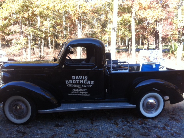 A vintage-looking truck with text on the side of it reading "Davis Brothers Chimney Sweep and Masonry."