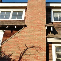 A finished chimney with red brick on a house.
