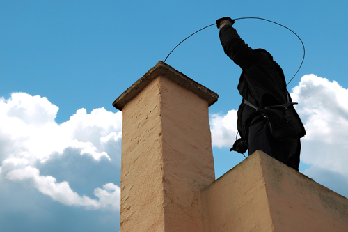 A person performing a service on a chimney.