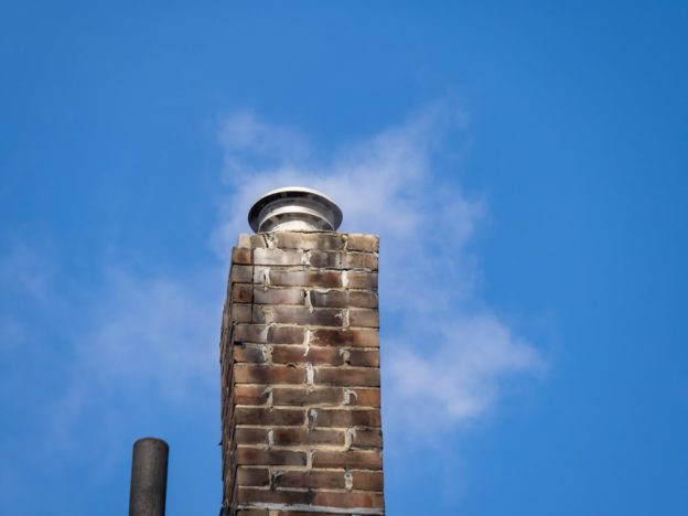 An old chimney with a blue sky in the background.